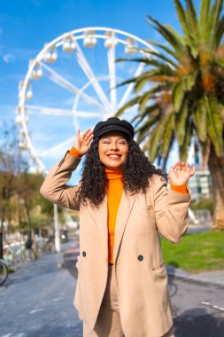 Şirin, şık, Latin bir kadın sıcak bir kış gününün tadını çıkarıyor.