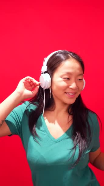 Студійне Фото Червоним Тлом Стильної Китайської Жінки Слухає Музику Мобільним — стокове відео