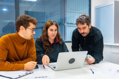 Ofiste dizüstü bilgisayarla çalışan modern bir endüstrinin mühendisleri.