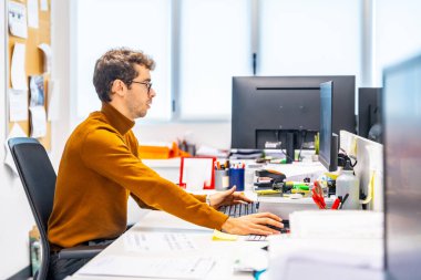 Enigneer bilgisayar kullanarak bir cnc fabrikasında metal bir parça tasarlıyor.