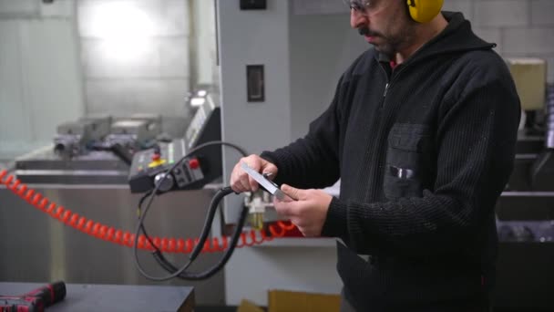 Mężczyzna Inżynier Stojący Fabryce Cnc Pomocą Słuchawek Bezpieczeństwa Pracy — Wideo stockowe