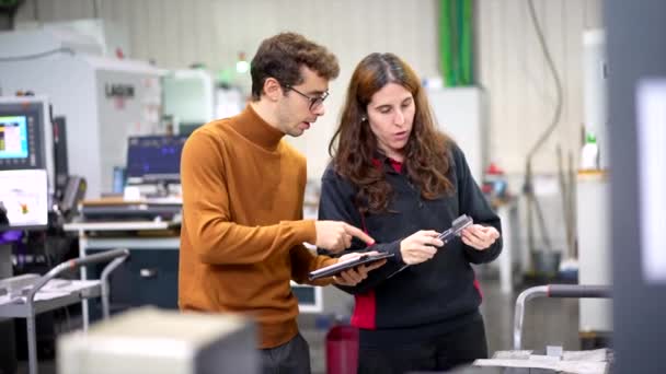 現代Cnc工場でデジタルタブレットを使用しながら話している2人のエンジニアのチーム — ストック動画