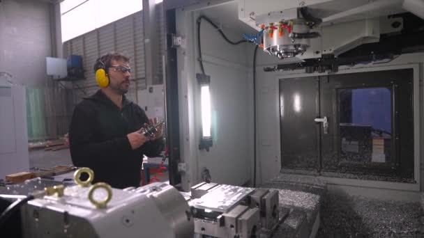 フライスCnc現代機械を使用して保護ゴーグルおよびヘッドフォンが付いている手動労働者 — ストック動画