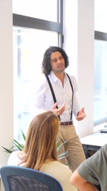 Çok ırklı gençlerle birlikte çalışan bir toplantıya liderlik eden adam.