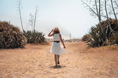 İspanya 'nın Cabo de Gata şehrinde bir yol boyunca yürüyen bir kadın.
