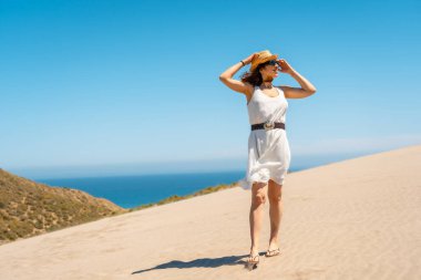 İspanya, Cabo de Gata 'da rüzgarlı bir günde kıyı manzaralı bir yerde duran kadın.