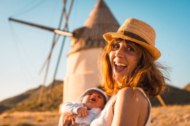 İspanya 'da Cabo de Gata' da eski yel değirmenlerini ziyaret eden mutlu bir kadın.