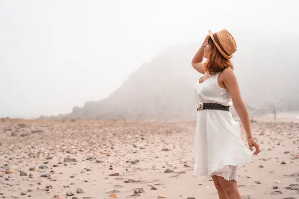 Woman in sun hat visiting a arid bay in Cabo de Gata, Spain