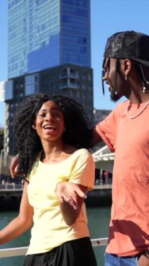 Şehirdeki genç Afro-Amerikan kadınları, yaşam tarzı çift kavramı, nehir kenarında çok gülüyorlar.