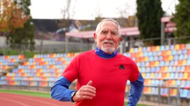 Kışın pistte koştuktan sonra gururlanan yorgun bir sporcunun portresi.