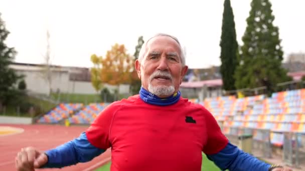 Kışın Pistte Koşmadan Önce Esneyen Mutlu Yaşlı Bir Adamın Fotokopi — Stok video