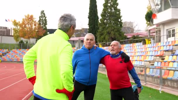 Mature Retired Male Friends Talking Stretching Running Outdoor Track — Stock Video