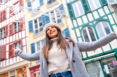 Düşük açılı bir fotoğraf. Mutlu stil sahibi bir kadının bir şehri ziyaret ederken kollarını kaldırması.