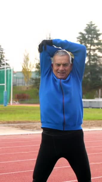 Uśmiechnięty Starszy Pan Sportowej Odzieży Rozgrzewa Się Torze Polu Zimie — Wideo stockowe