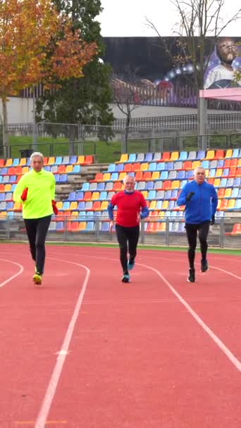 Vista Frontal Três Homens Esportivos Maduros Correndo Uma Pista Atletismo — Vídeo de Stock