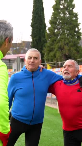 成熟的退休男性朋友在室外跑道上聊天和伸展身体 — 图库视频影像