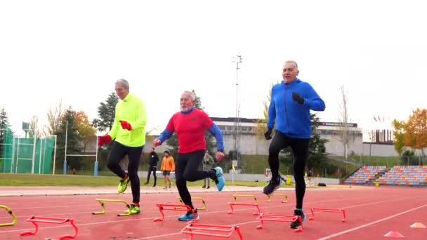 Sportieve Senior Die Kegels Startblokken Een Atletiekbaan Plaatst Winter Buiten — Stockvideo