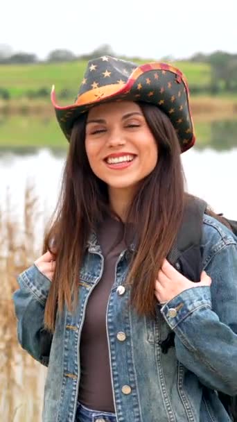 Χαμογελώντας Λαμπερή Γυναίκα Καουμπόικο Καπέλο Περπατώντας Ένα Αγροτικό Μονοπάτι Ενώ — Αρχείο Βίντεο