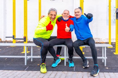 Senior men gesturing to be okay after exercising in an outdoor sport ground clipart