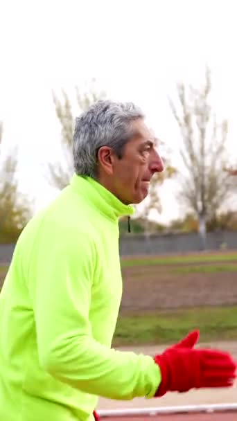 Kış Aylarında Atletizm Sahasında Koşan Yaşlı Bir Adamın Fotokopi Alanı — Stok video