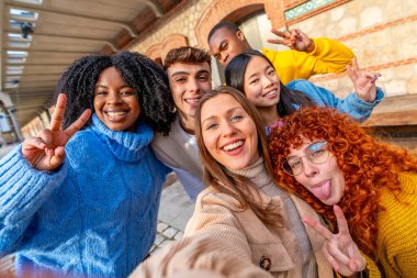 Arkadaşlar şehirde selfie çekerken yüzlerini buruşturuyorlar.