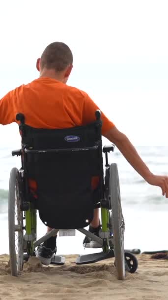 ビーチで車椅子に乗っている障害者が海のそばで自由を感じている — ストック動画