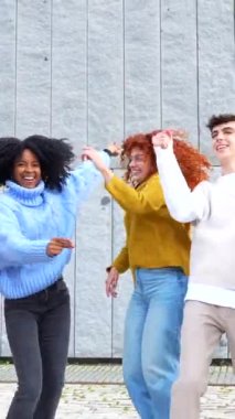 Çeşitli ve çok ırklı arkadaşlar sokaklarda kutlama ve dans ediyorlar.