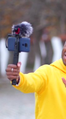 Afrikalı gençler sokakta video çekerken gülümsüyor ve zafer işareti yapıyorlar.