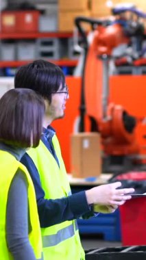 Çok kültürlü mühendisler, robot silah üretim hattında evrak işleriyle uğraşıyorlar.