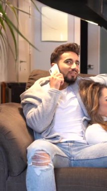 Kanepede oturup televizyon izleyen beyaz bir çift. Romantik bir akşamda bir çiftin yaşam tarzı. 4k video