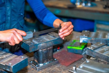 Kesik parmaklı bir operatör, bir CNC makine merkezi aracılığıyla yüksek teknolojili, sayısal kontrol atölyesinde değirmen kesicileri olan bir şirkette çalışıyor.
