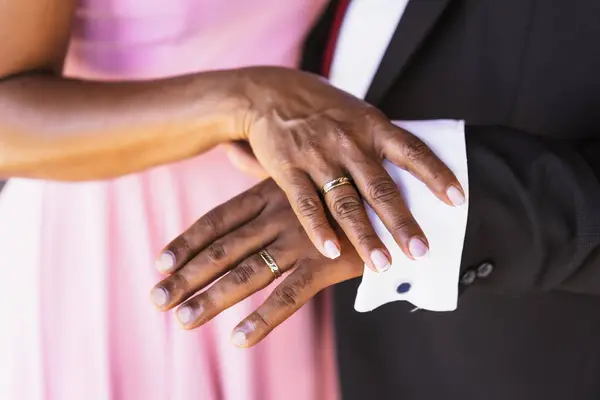 Black ethnic wedding couple showing rings at a wedding, marriage ceremony