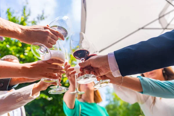 Friends toast at an event or wedding, detail of hands toasting