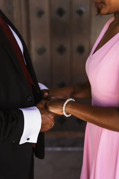 Black ethnic groom holding hands at a beautiful wedding, marriage portraits