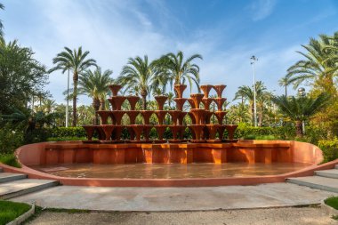 Glorieta Fountain in the Palm Grove Park in the city of Elche. Spain clipart