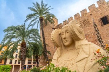 Lady of Elche next to the Altamira Palace and the palm grove park in Elche. Spain clipart