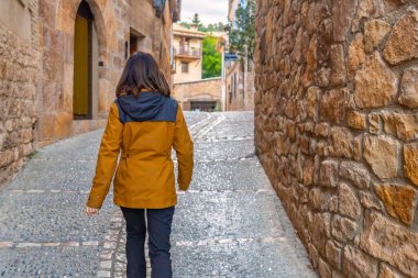 İspanya 'nın ortaçağ şehri Huesca' daki Alquezar Pyrenean köyünün sokaklarında yürüyen bir kadın.