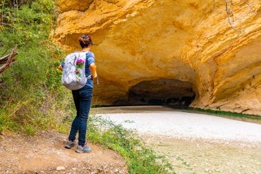 Alquezar 'daki Vero nehri yolundaki mağarada sırt çantalı bir turist. Huesca Pireneleri
