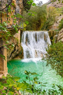 Şelalenin güzel manzarası, Alquezar 'daki Vero Nehri geçitlerinin yanındaki patikanın yanında. Huesca Pireneleri, dikey fotoğraf