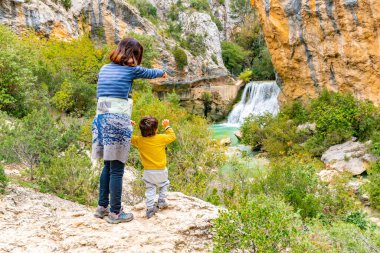 Kadın ve oğlu Alquezar 'daki Vero Nehri patikasındaki şelalede. Pireneler