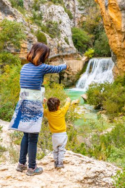 Kadın ve oğlu Alquezar 'daki Vero Nehri patikasındaki şelalede. Pireneler
