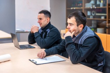 Mühendisler bir lojistik ve makine inşaat fabrikasının toplantı odasında toplandılar.