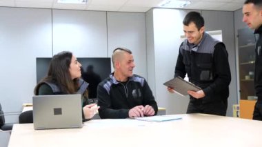 Toplantı odasındaki bir fabrikada çalışan işçi ve mühendisler.