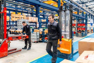 Modern bir lojistik fabrikasında çalışan erkek işçiler.