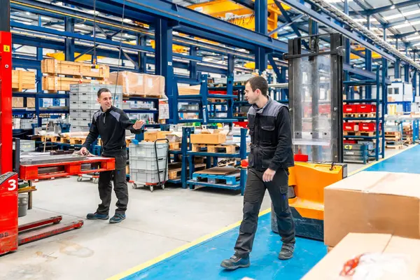 Team of warehouse and handling workers in a modern logistic factory
