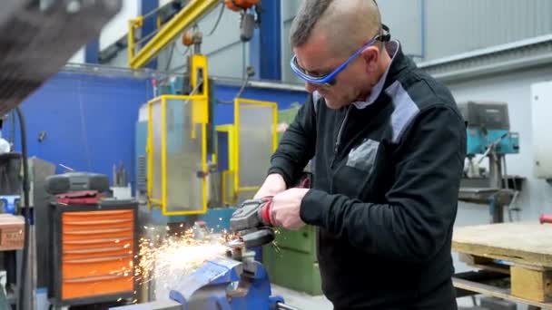 工厂中使用电动砂轮磨削带保护装置的工人 — 图库视频影像