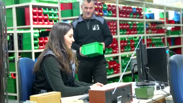 ロジスティックセンターで在庫を作るためにコンピュータを使用する2人の男性と女性の労働者 — ストック動画