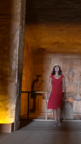 ナセル湖に隣接するヌビアのエジプト南部 アブシンベル神殿内の室内を訪れた若い女性 ファラオラムセス2世の神殿 4Kビデオ — ストック動画
