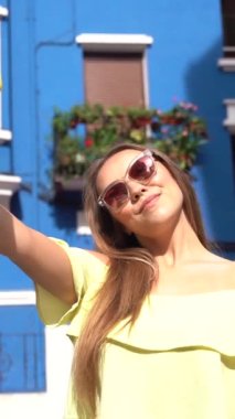 Yaz yaşam tarzı, mavi yüzlü bir evde selfie çeken sarışın bir kadın.