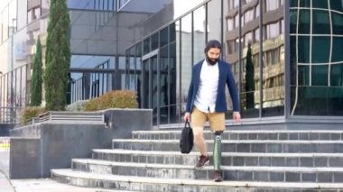 Güneşli bir günde protez bacaklı bir işadamı ofis binasına geliyor.